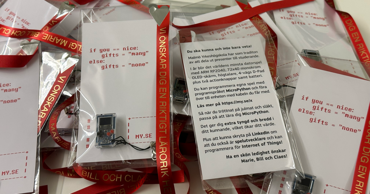 Flera små gratulationskort med ett datorchip påsatt är staplade tillsammans, varje kort visar kodliknande text: ”om du == trevligt: presenter = många andra: presenter = inga.” Röda band med svensk text syns också.