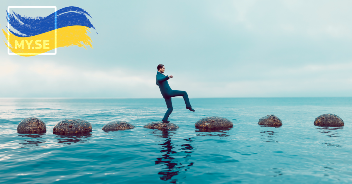 En person i kostym balanserar på klippor tvärs över vattnet under en molnig himmel. Längst upp till vänster visas ett blått och gult penseldrag med texten ”MY.SE”.