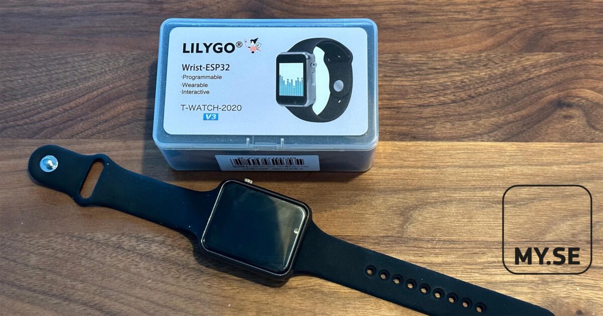 En svart smartklocka med rektangulär urtavla ligger på en träyta bredvid en plastlåda märkt LILYGO Wrist-ESP32 T-WATCH-2020 V3. MY.SE-logotypen syns i det nedre högra hörnet.