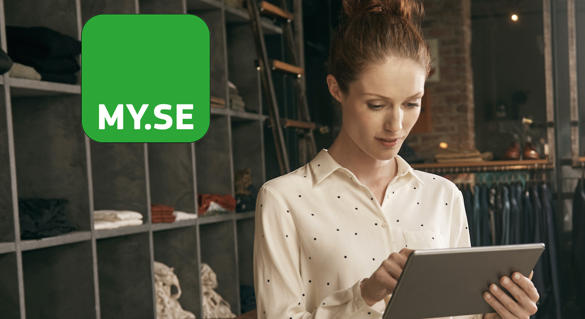 En kvinna i vit prickig blus använder en surfplatta i en modern klädbutik. En grön fyrkantig logotyp med texten ”MY.SE” visas till vänster i bilden.