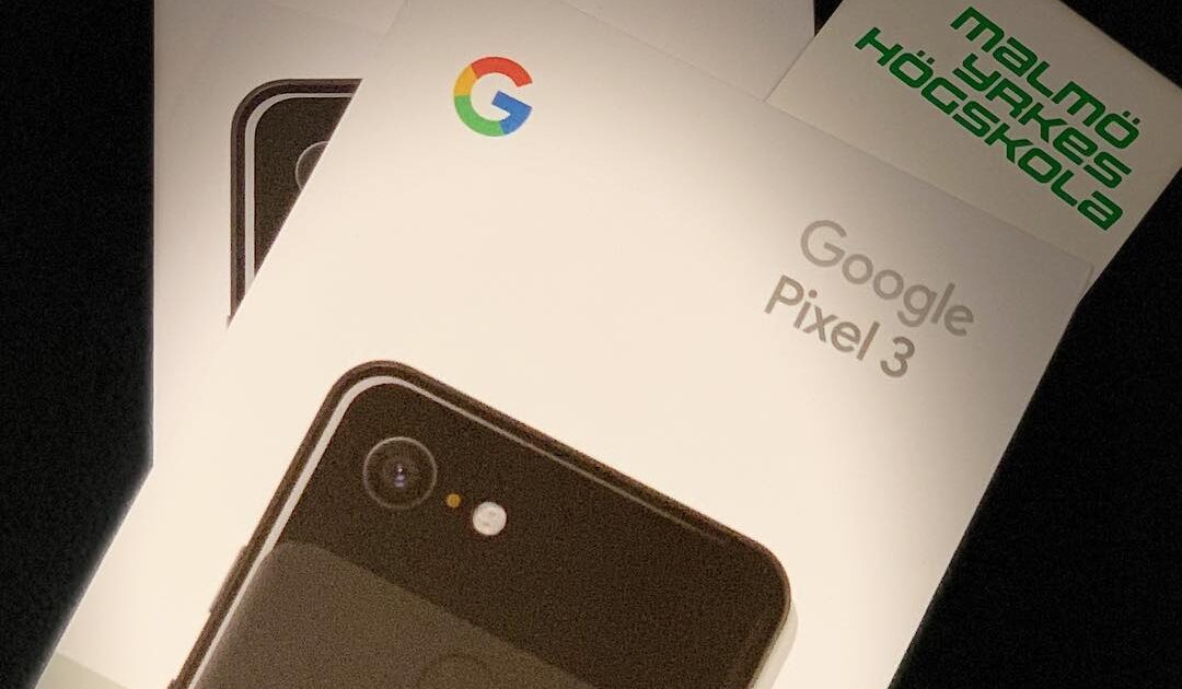 Två Google-smartphones i kartonger, en Pixel 3 och en Pixel 3 XL, ligger staplade ovanpå varandra. Ett kort märkt Malmö Yrkeshögskola är undanstoppat bakom Pixel 3-kartongen.