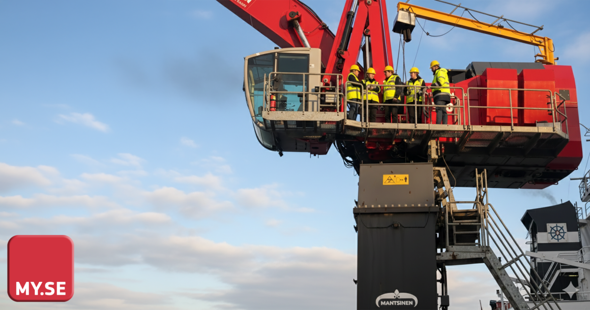 En grupp arbetare i skyddsutrustning står på en röd industrikranplattform, högt ovanför marken. Himlen är mestadels klar med spridda moln, och MY.SE-logotypen visas i det nedre vänstra hörnet.